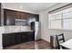 Kitchen featuring stainless steel appliances, dark cabinets and countertops with a grey backsplash and tile flooring at 14419 Dahlia St, Thornton, CO 80602