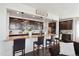 Open kitchen design featuring dark cabinetry, granite countertops, pendant lighting, and a breakfast bar with seating at 14419 Dahlia St, Thornton, CO 80602