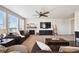 Cozy living room with a fireplace, large windows, sofa, ceiling fan, and a TV for relaxation and entertainment at 14419 Dahlia St, Thornton, CO 80602
