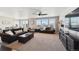 Bright living room with large windows, two sofas, a ceiling fan, fireplace, and an adjacent dining area at 14419 Dahlia St, Thornton, CO 80602