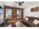 Living room with a wood accent wall, decorative guitar, leather couch, area rug, and windows for natural light at 14419 Dahlia St, Thornton, CO 80602