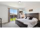 Primary bedroom features a wood bed frame, plush bedding and a sliding glass door with backyard and fence views at 14419 Dahlia St, Thornton, CO 80602