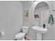 Powder bathroom showcasing a pedestal sink, toilet, and decorative mirror, creating a functional space at 6350 N Lisbon St, Aurora, CO 80019