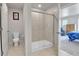 Bathroom featuring a glass-enclosed shower, toilet, and access to the bedroom at 6350 N Lisbon St, Aurora, CO 80019