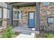 Charming front porch showcases stone detailing, modern blue door, and an inviting entrance at 6350 N Lisbon St, Aurora, CO 80019