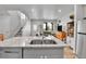 Modern open-concept kitchen featuring island with stainless sink and a view into the living room at 6350 N Lisbon St, Aurora, CO 80019