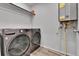 Laundry room featuring modern washer and dryer appliances and tankless hot water system at 6350 N Lisbon St, Aurora, CO 80019