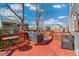 A cozy red deck with outdoor seating and a beautiful view, perfect for relaxing and entertaining guests at 9898 Mulberry Way, Highlands Ranch, CO 80129