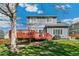 Backyard featuring a two-story home, a wooden deck, and well-maintained landscaping at 9898 Mulberry Way, Highlands Ranch, CO 80129