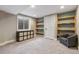 Finished basement featuring built-in shelving, neutral walls, and an egress window at 9898 Mulberry Way, Highlands Ranch, CO 80129