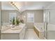 Bright bathroom featuring a dual sink vanity, soaking tub, and glass-enclosed shower at 9898 Mulberry Way, Highlands Ranch, CO 80129