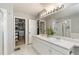 Bright bathroom featuring double sinks, white cabinets, a glass shower, and walk-in closets at 9898 Mulberry Way, Highlands Ranch, CO 80129