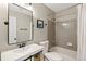 Cozy bathroom featuring gray tile, a shower-tub, and a modern sink at 9898 Mulberry Way, Highlands Ranch, CO 80129