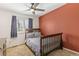 Bedroom with a ceiling fan, neutral carpet, and a rustic red accent wall at 9898 Mulberry Way, Highlands Ranch, CO 80129