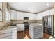Bright kitchen featuring white cabinetry, stainless steel appliances, granite countertops, and a central island at 9898 Mulberry Way, Highlands Ranch, CO 80129