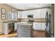 Bright kitchen with white cabinets, center island, stainless steel appliances, and hardwood floors at 9898 Mulberry Way, Highlands Ranch, CO 80129