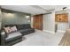 Basement living room with a large sofa and an industrial-style sliding barn door at 9898 Mulberry Way, Highlands Ranch, CO 80129