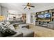 Comfortable living room with plush sectional, built-in shelving, and a view into the bright kitchen at 9898 Mulberry Way, Highlands Ranch, CO 80129