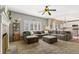 Inviting living room with a large sectional, cozy fireplace, and bright windows with shutters at 9898 Mulberry Way, Highlands Ranch, CO 80129