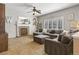 Spacious living room with brick fireplace, large sectional, and bright windows with shutters at 9898 Mulberry Way, Highlands Ranch, CO 80129