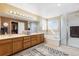 Bright bathroom features double sinks, vanity lighting, bathtub, and glass enclosed shower at 13277 Elizabeth St, Thornton, CO 80241