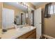 Bathroom featuring wood cabinets, large mirror, and plenty of storage space at 13277 Elizabeth St, Thornton, CO 80241