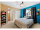 Bedroom with bright blue accent wall, closet with double doors, and light-colored carpet at 13277 Elizabeth St, Thornton, CO 80241
