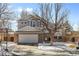 Two story home with a brick-accented front, driveway, basketball hoop, and well-maintained lawn with winter snow at 13277 Elizabeth St, Thornton, CO 80241
