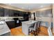 Spacious kitchen featuring an island with seating, a built-in desk area, and wood flooring at 13277 Elizabeth St, Thornton, CO 80241