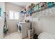 Bright laundry room with washer, dryer, shelving for storage, and folding area at 13277 Elizabeth St, Thornton, CO 80241