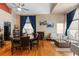 Well-lit living room with hardwood floors, dining table, and blue curtains at 13277 Elizabeth St, Thornton, CO 80241