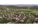 Aerial view of a residential community nestled within a golf course and mature trees, offering scenic views and lush landscaping at 1102 Buffalo Ridge Rd, Castle Pines, CO 80108