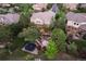 Aerial view of a private backyard featuring mature trees, a custom water feature, a trampoline, and an outdoor seating area at 1102 Buffalo Ridge Rd, Castle Pines, CO 80108