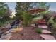 Landscaped backyard with tranquil waterfall and lounge area under a shade umbrella at 1102 Buffalo Ridge Rd, Castle Pines, CO 80108