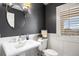 Bathroom featuring a pedestal sink, neutral colors, decorative mirror and window with privacy shutters at 1102 Buffalo Ridge Rd, Castle Pines, CO 80108
