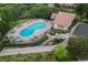 Aerial view of a community pool with plenty of lounge seating, tables, and a pool house amidst well-maintained landscaping at 1102 Buffalo Ridge Rd, Castle Pines, CO 80108