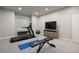 Finished basement features an exercise area equipped with a treadmill, bench, and TV for workouts at 1102 Buffalo Ridge Rd, Castle Pines, CO 80108