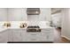 Modern kitchen with stainless steel range hood, white cabinets, and marble counters at 1102 Buffalo Ridge Rd, Castle Pines, CO 80108