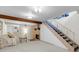 Finished basement features a cozy fireplace, exposed beam, and stairs leading to the upper level at 6328 E Mississippi Ave, Denver, CO 80224