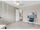 Neutral bedroom with spacious closet, soft carpet, and desk next to bathroom entrance at 6328 E Mississippi Ave, Denver, CO 80224
