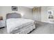 Cozy bedroom features a decorative bedspread, a neutral color palette, and a closet for storage at 6328 E Mississippi Ave, Denver, CO 80224