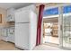 Well-lit kitchen featuring modern white appliances and a doorway to a backyard at 6328 E Mississippi Ave, Denver, CO 80224