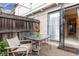 Private patio with chairs, table, fence, and entrance to the home at 6328 E Mississippi Ave, Denver, CO 80224