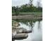 Picturesque pond featuring stone accents and tree reflections on a still day near the property at 6328 E Mississippi Ave, Denver, CO 80224