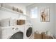 Functional laundry room with modern appliances, storage shelves, and a window at 23721 E 40Th Ave, Aurora, CO 80019