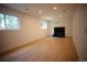 Finished basement with recessed lighting, windows, wood-look floors, and a black fireplace at 1552 S Fairplay Way, Aurora, CO 80012