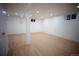 Spacious basement area featuring wood-look flooring, recessed lighting, and freshly painted white walls at 1552 S Fairplay Way, Aurora, CO 80012