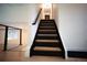 Stylish staircase featuring dark wood steps and sleek metal railings, leading to upper levels of the home at 1552 S Fairplay Way, Aurora, CO 80012