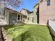 Landscaped backyard with artificial turf, green siding and a brick section of the home at 2245 Whistler Dr, Longmont, CO 80504