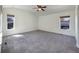 Spacious bedroom with plush gray carpeting, two windows, and a ceiling fan at 2245 Whistler Dr, Longmont, CO 80504